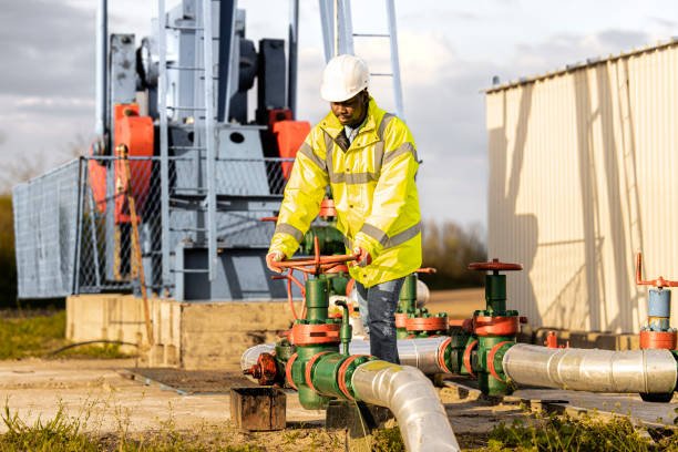 Oil field worker checking pipeline pressure of an oil rig.